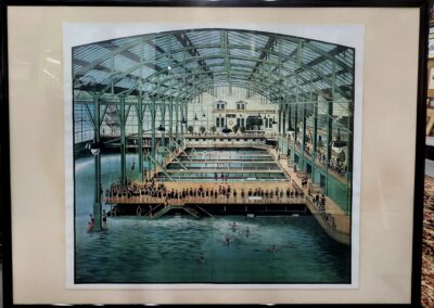 Historic indoor swimming pool with swimmers and spectators.