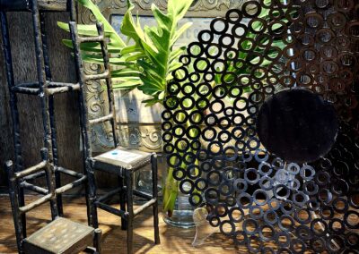 Artistic chairs and decorative screen with green plants in a cozy setting.