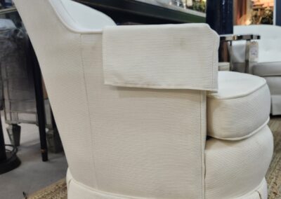 Elegant cream-colored upholstered armchair with a cushioned seat and backrest.