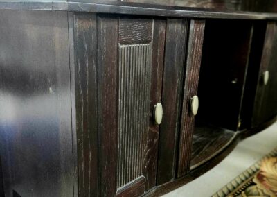 Close-up of dark wooden cabinet doors with textured panels and round knobs.