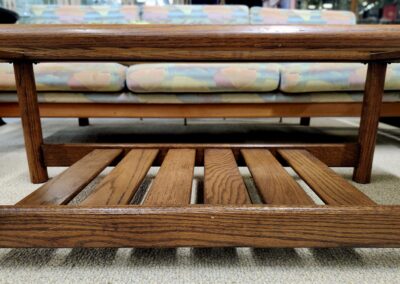 Close-up of a wooden slatted bench with cushions on top.