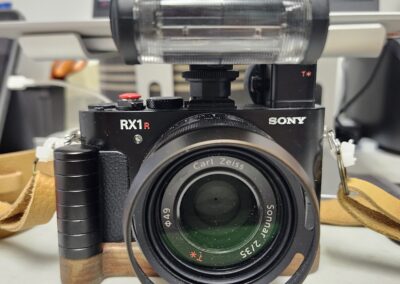 Sony camera with lens and flash attachment on a desk.