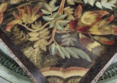 Decorative floral embroidery on fabric with a dark border.