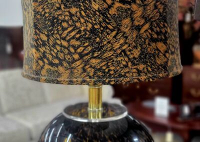 Decorative table lamp with a speckled golden and black design.