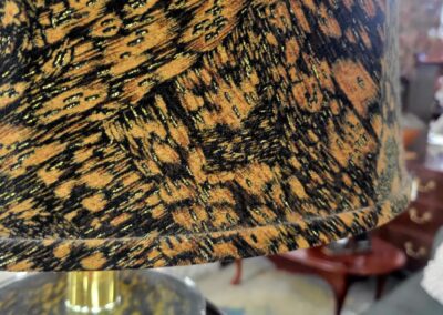 Close-up of a textured, patterned lampshade with warm yellow and black tones.