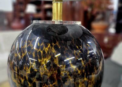 Round table lamp with a leopard print patterned base and a white shade.