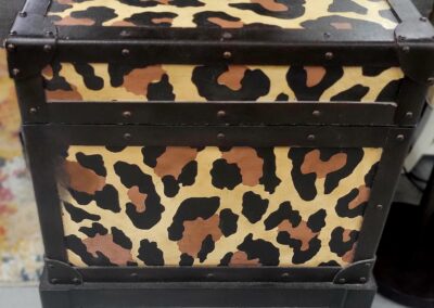A leopard print storage box on a shelf.