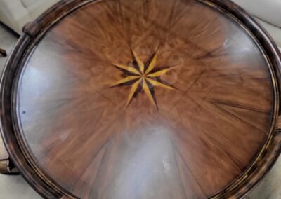 Round wooden table with a star pattern in the center.