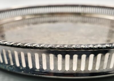 Close-up of a silver tray with decorative cut-out edges.