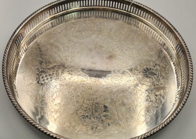 An ornate silver serving tray with intricate floral engravings.