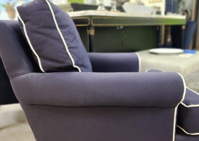 Cozy navy armchair with white piping in a bright, stylish room.