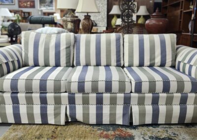 Striped cushioned sofa with blue, white, and beige tones in a cozy living room.