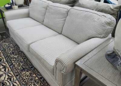 A beige striped sofa with cushions in a cozy living room.