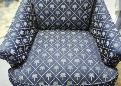 Plush armchair with blue fabric and gold geometric pattern.