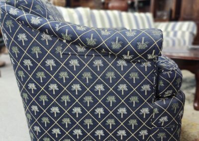 Blue patterned armchair with palm tree motifs in a cozy setting.