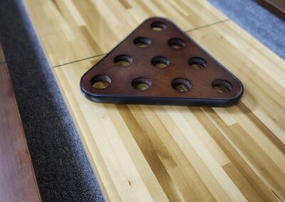 Triangular billiard rack on a wooden pool table.