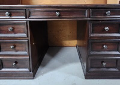 Vintage wooden desk with multiple drawers and a central knee space.