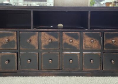 Rustic wooden cabinet with multiple drawers in worn condition.
