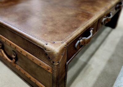 Vintage brown leather suitcase with sturdy handles and metal accents.