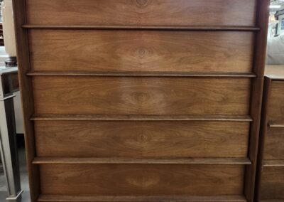 Mid-century modern wooden dresser with five drawers in a warm finish.