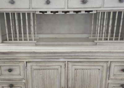 Vintage white distressed wooden cabinet with drawers and cupboards.