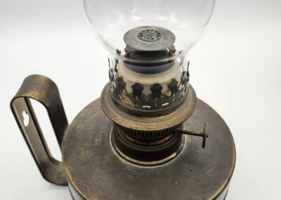 Vintage brass oil lamp with glass chimney and handle.