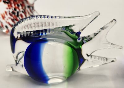 Close-up of a colorful glass fish figurine with blue and green accents.