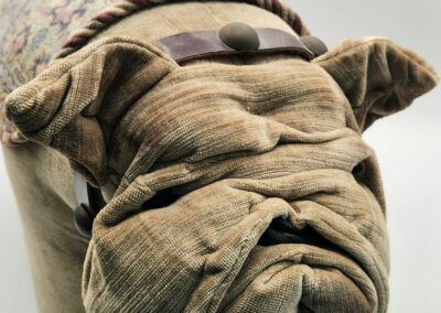 A dog-shaped pillow with a textured fabric design.