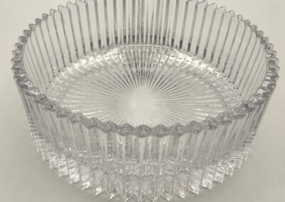 Clear ribbed glass bowl with textured base and scalloped rim.