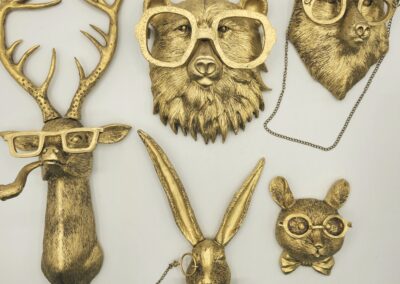 Brass animal heads with glasses, including deer, bear, owl, and antelope.