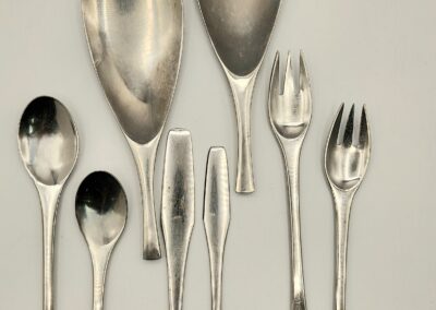 A set of vintage silver serving utensils with intricate designs.