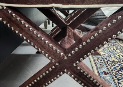 Close-up view of a metal structure with rivets forming an X shape.