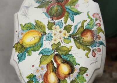 Decorative ceramic plate with colorful fruit and floral design.