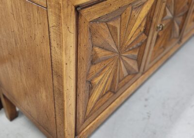 Close-up of a wooden chest with geometric carved patterns.