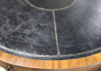 Close-up of a round table with a black marble top and wooden edge.