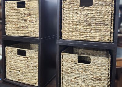 Dark brown shelving unit with four woven wicker baskets.