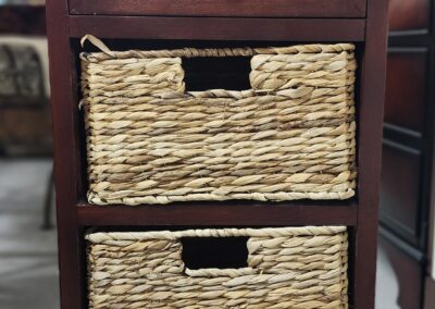 Wooden cabinet with two woven basket drawers.