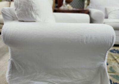 White upholstered armchair with a rolled arm design.