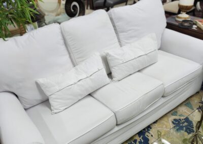 Elegant white sofa with plush cushions and pillows.
