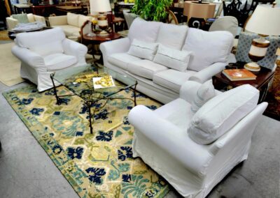 Elegant white sofa set with a floral patterned rug in a stylish living room.