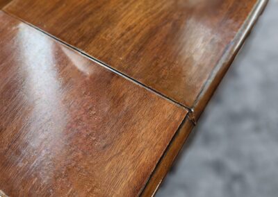 Close-up of a wooden table corner with a visible crack.