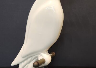 A smooth white ceramic bird sculpture on a small base.