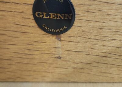 Close-up of a Glenn McCauley furniture maker label on wood.