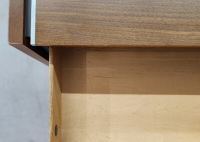 Open wooden drawer in a wooden cabinet.