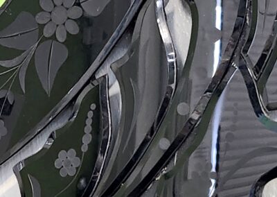 Close-up of a decorative glass surface with floral and abstract patterns.