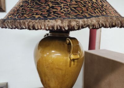 A rustic table lamp with a ceramic base and a woven lampshade.