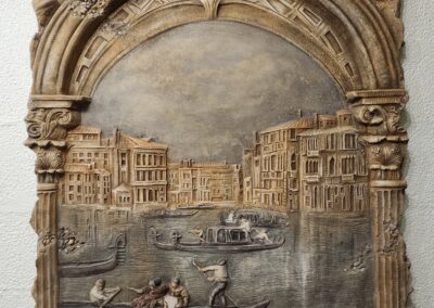 Ornate relief sculpture depicting a Venetian canal scene with gondolas.
