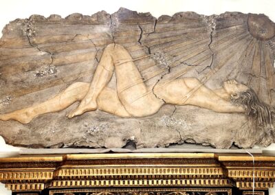 Ancient relief sculpture of two intertwined figures in an intimate pose.