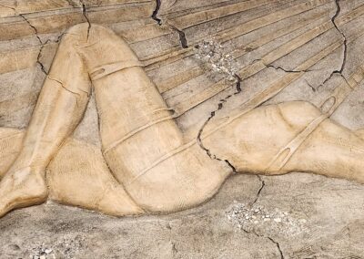 Ancient carved relief of a reclining figure on stone.