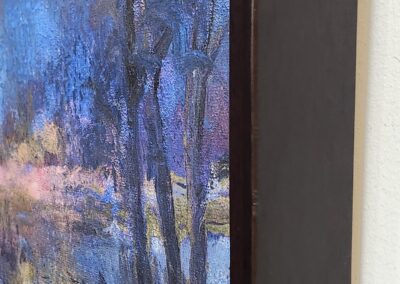 Close-up of a framed artwork showing a tree and reflections in water.